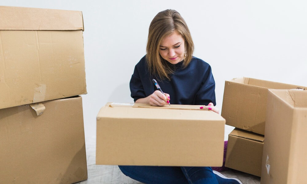 žena piše sadržaj svake kutije na nju